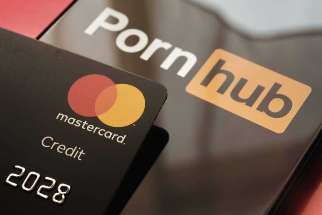 Stafford, United Kingdom - December 12 2020: Mastercard Credit Card placed on top of PornHub web site logo on seen on the smartphone.